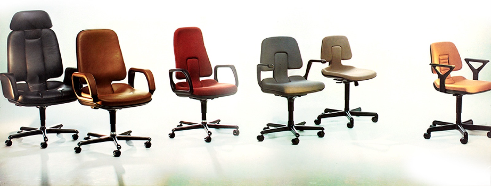 A row of mismatched office chairs on a white background